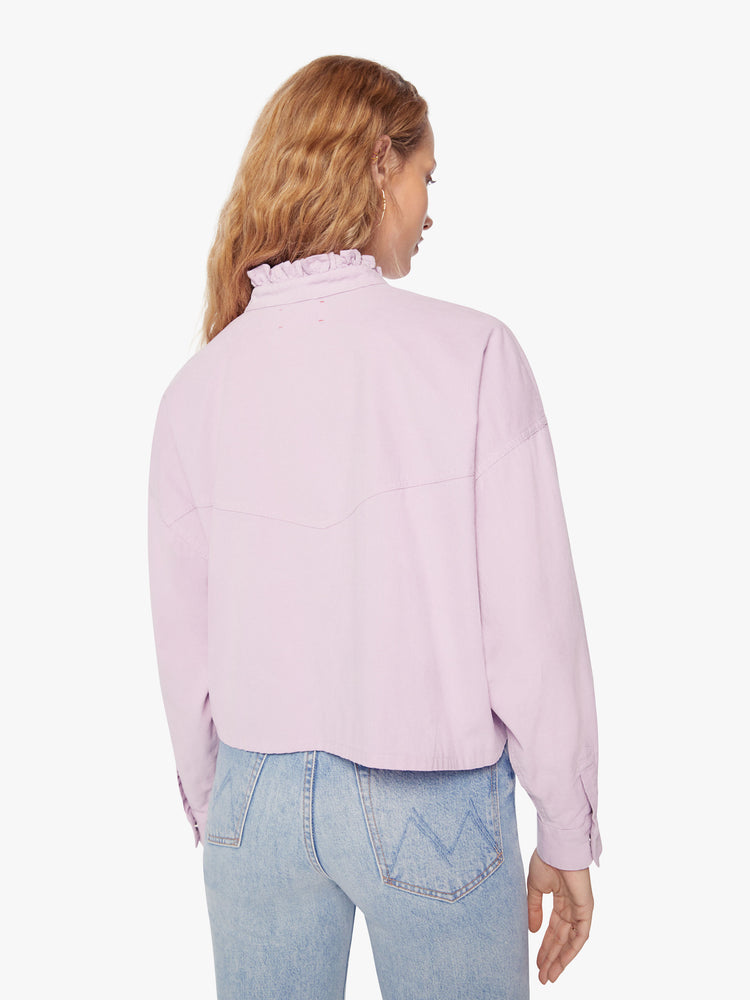 Back view of a woman soft lilac shirt with a ruffled V-neck that buttons, drop shoulders, long sleeves, a cropped hem and a boxy fit.
