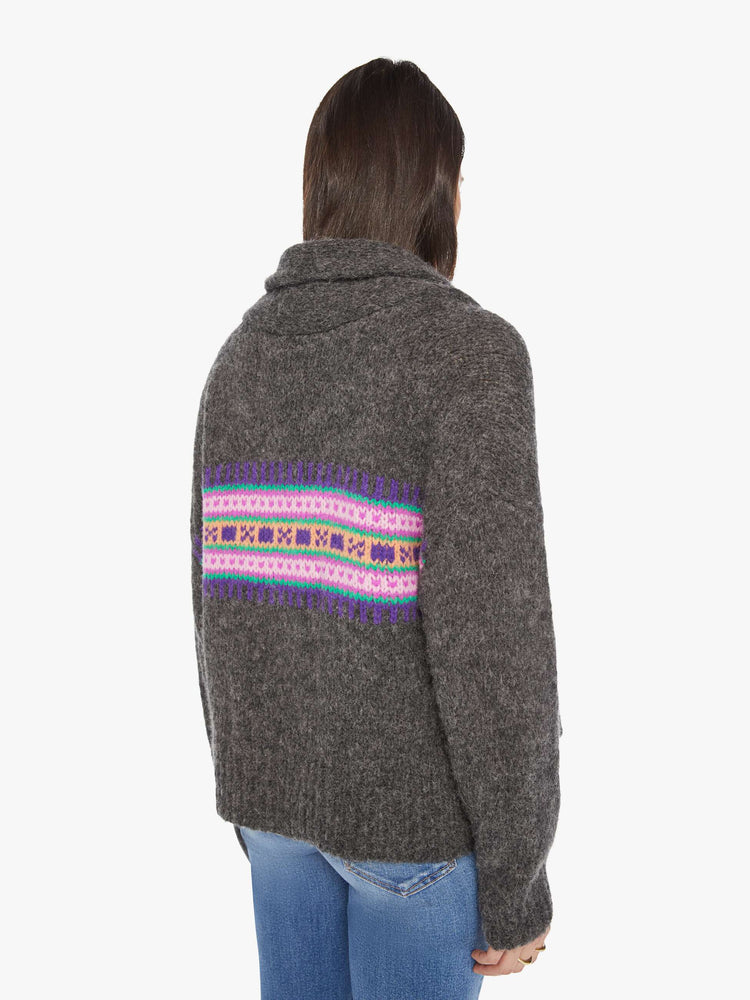 Back view of a woman cardigan with a shawl collar, drop shoulders and buttons down the front with a colorful knit pattern across the chest.