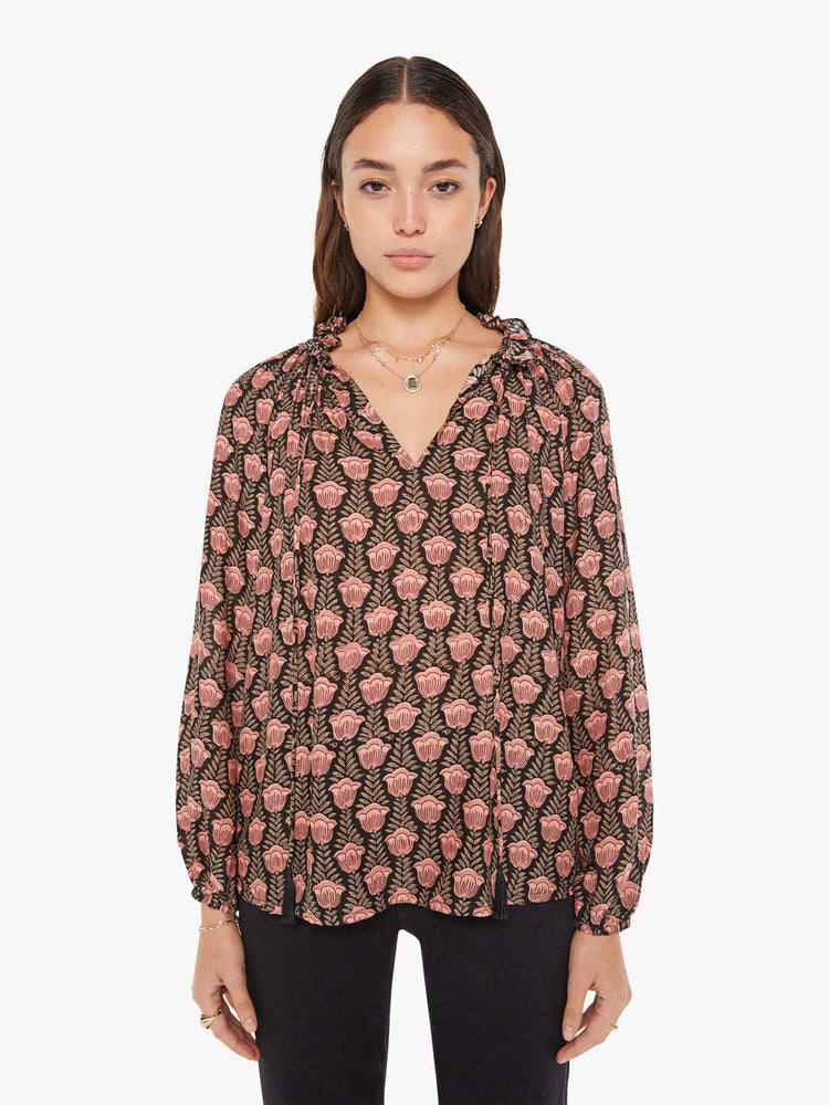 Front view of a womens blouse with a black and pink floral print and balloon sleeves.