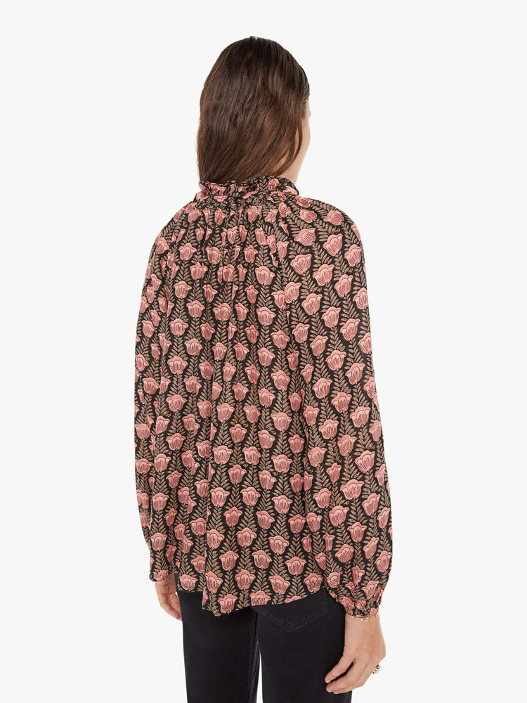 Back view of a womens blouse with a black and pink floral print and balloon sleeves.