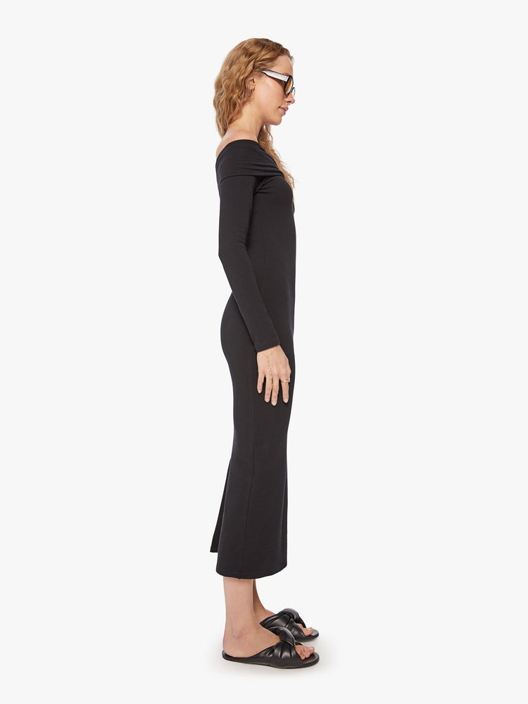 Side view of a black off-the-shoulder midi dress with long sleeves and a calf-length hem with slim flit.