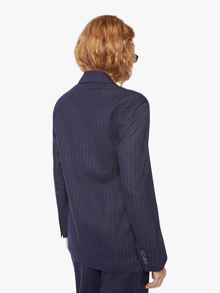 Back view of a woman wool navy blazer with a V-neck, padded shoulders, a button closure and a slightly narrow fit.
