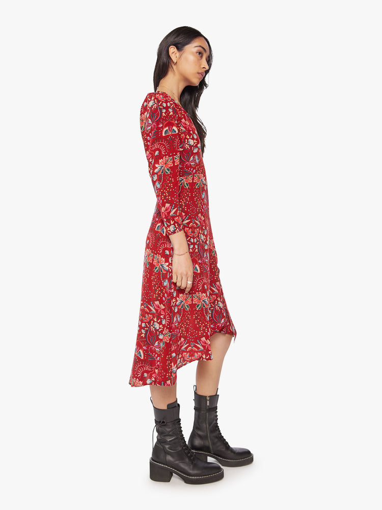 Side view of a woman red silk wrap midi dress with a V-neck, cropped long sleeves, and a wrapped design that ties at the waist.