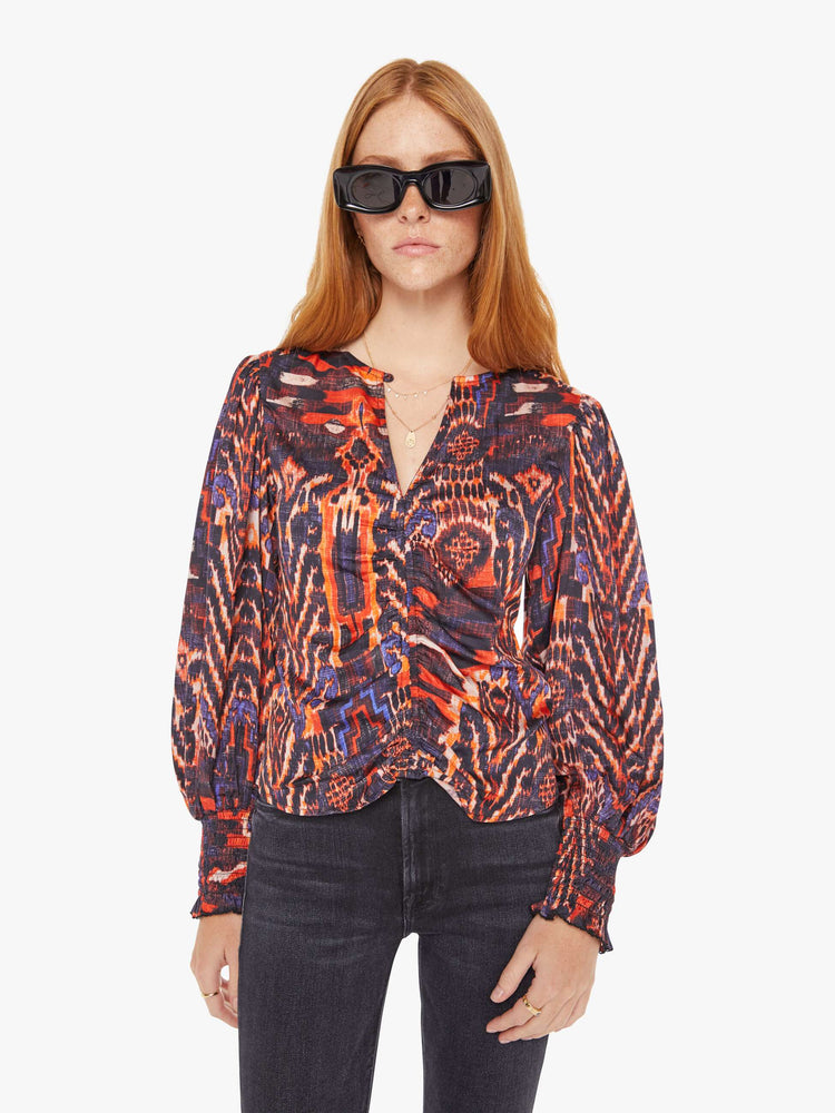 Front view of a womens blouse with a vibrant multi color print and balloon sleeves. 