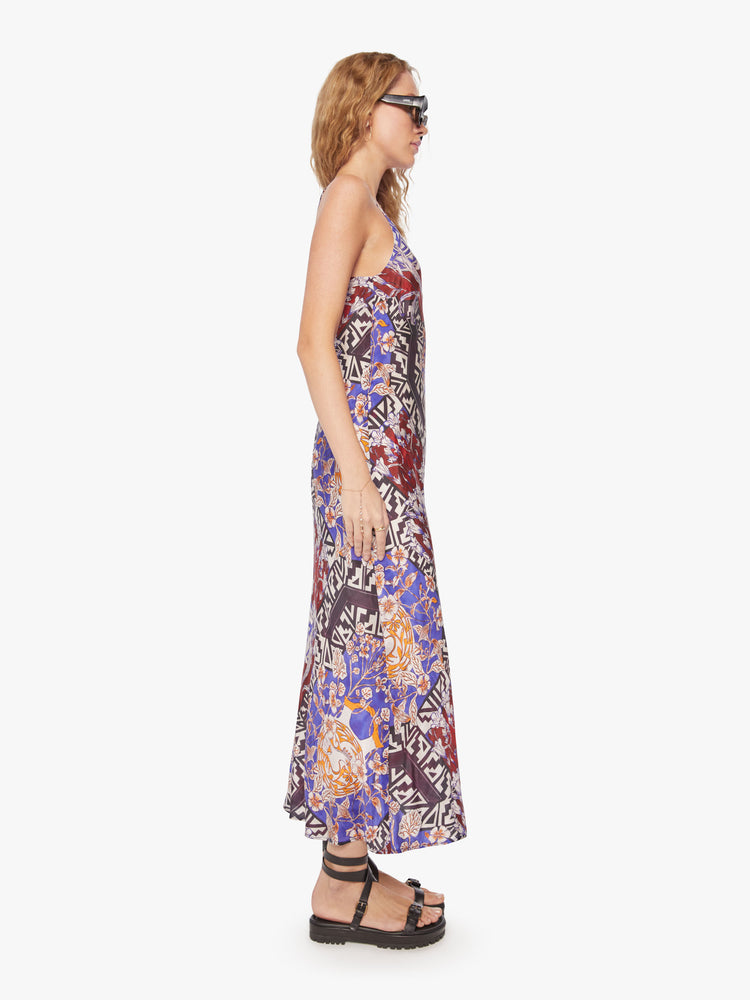 Side view of a woman slip dress in bold prints and modern neutrals, with a V-neck, thin straps, an ankle-length hem and a flowy fit.