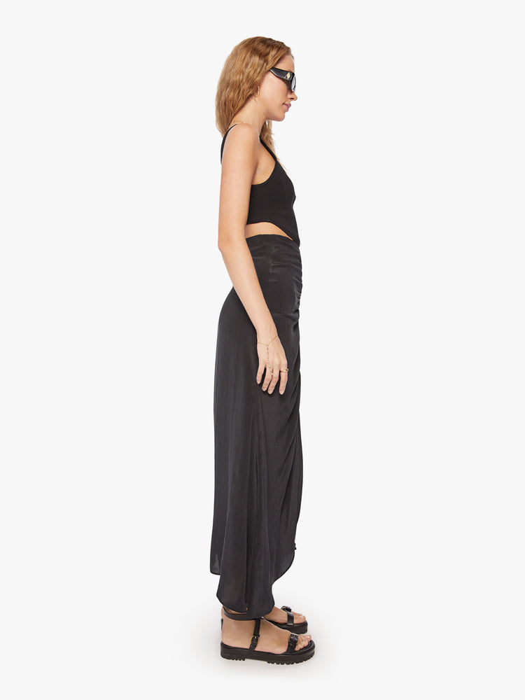 Side view of a woman maxi skirt in bold prints and modern neutrals with a high rise, gathered seam down the front and a flowy fit that hits at the ankle.