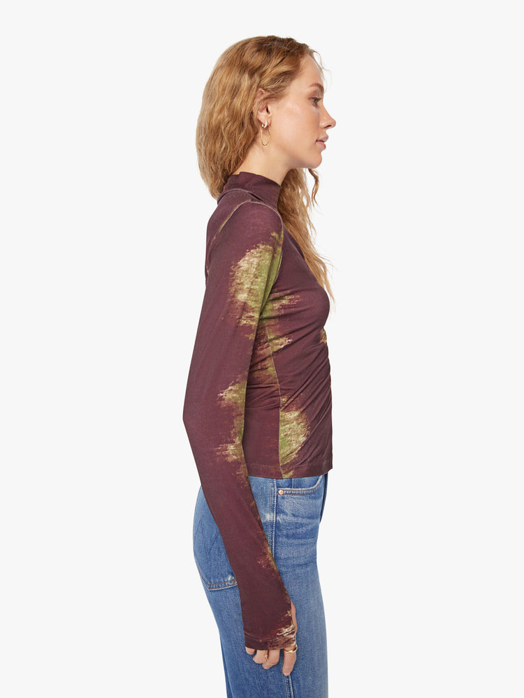 Side view of a woman long sleeve turtleneck in bold prints and modern neutrals, with a gathered seam down the front, thumbholes and a narrow fit.