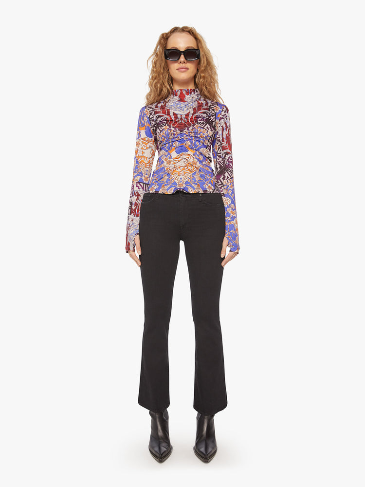 Full body view of a woman long sleeve turtleneck in bold prints and modern neutrals, with a gathered seam down the front, thumbholes and a narrow fit.