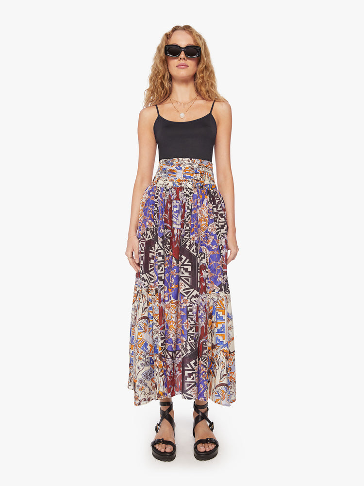 Front view of a woman maxi skirt in  bold prints and modern neutrals, with a super high rise, tiered skirt, uneven hem and a flowy fit.