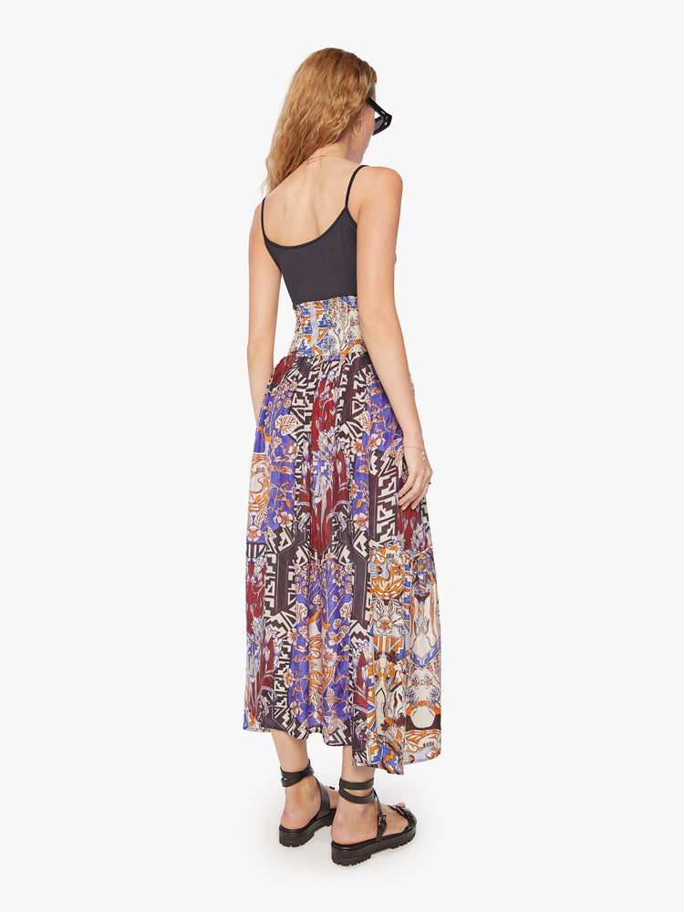 Back view of a woman maxi skirt in bold prints and modern neutrals, with a super high rise, tiered skirt, uneven hem and a flowy fit.