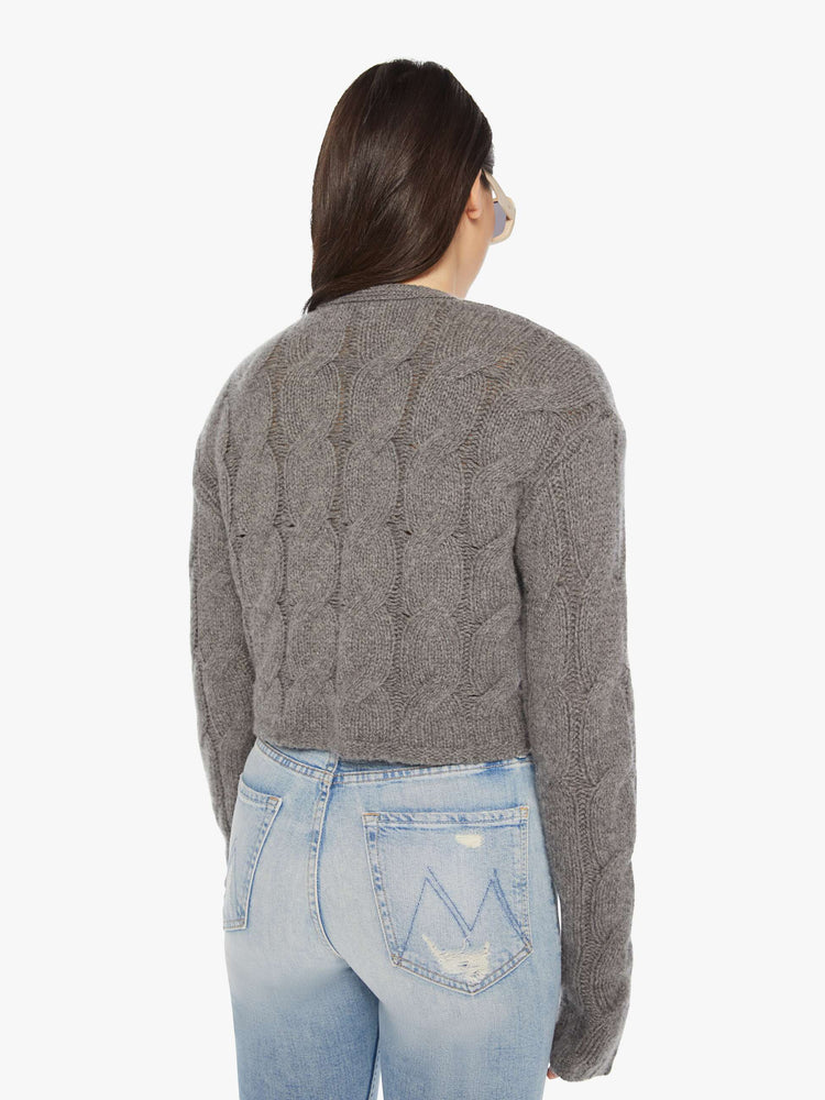 Back view of a woman dark grey hue with cable knit details cropped sweater designed with a V-neck, buttons down the front and a slim, cropped fit.