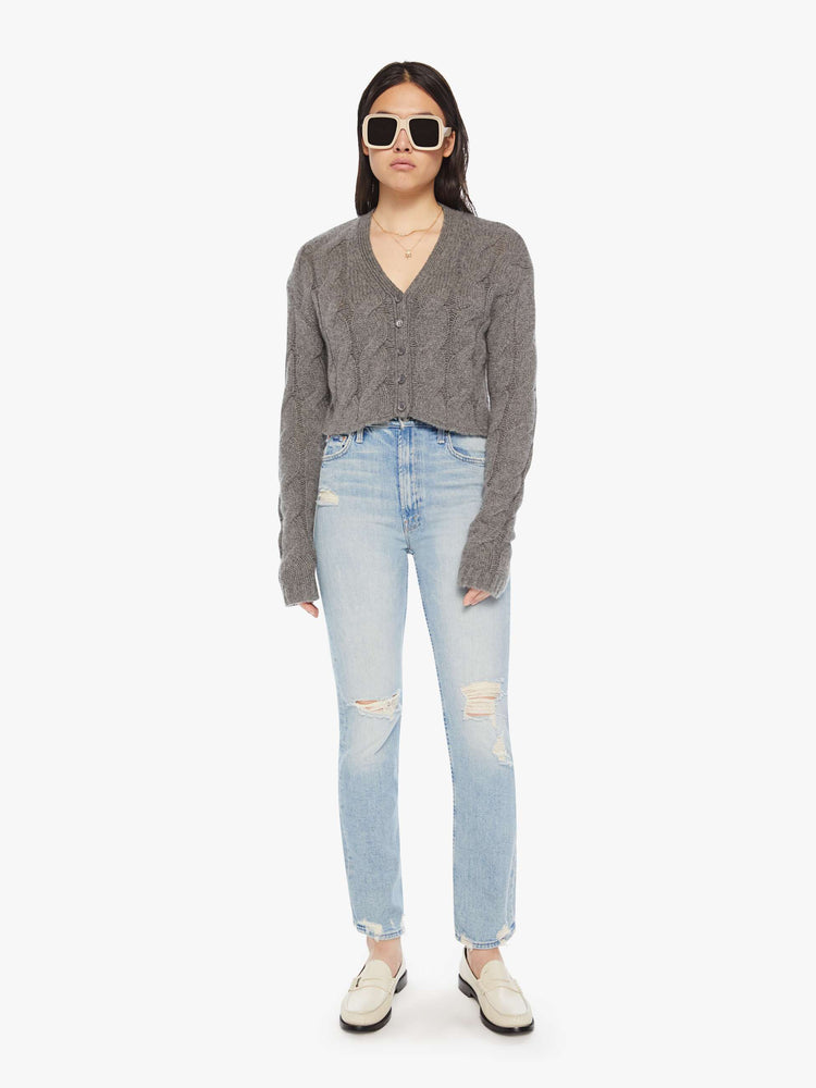 Full body view of a woman dark grey hue with cable knit details cropped sweater designed with a V-neck, buttons down the front and a slim, cropped fit.