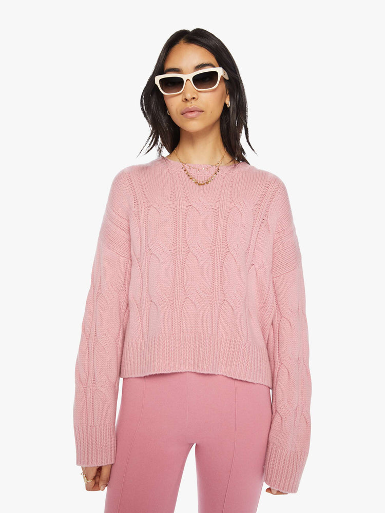 Front view of a woman pink knit sweater with crew neck, drop shoulders, extra-long sleeves and a loose fit.