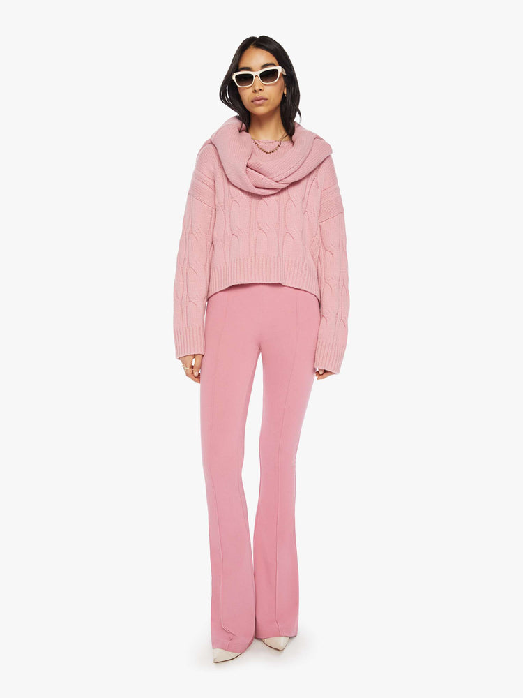 Full body view of a woman pink knit sweater with crew neck, drop shoulders, extra-long sleeves and a loose fit.