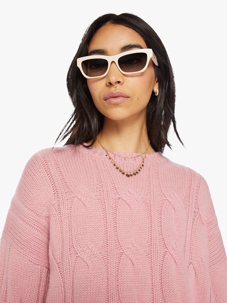 Close up view of a woman pink knit sweater with crew neck, drop shoulders, extra-long sleeves and a loose fit.