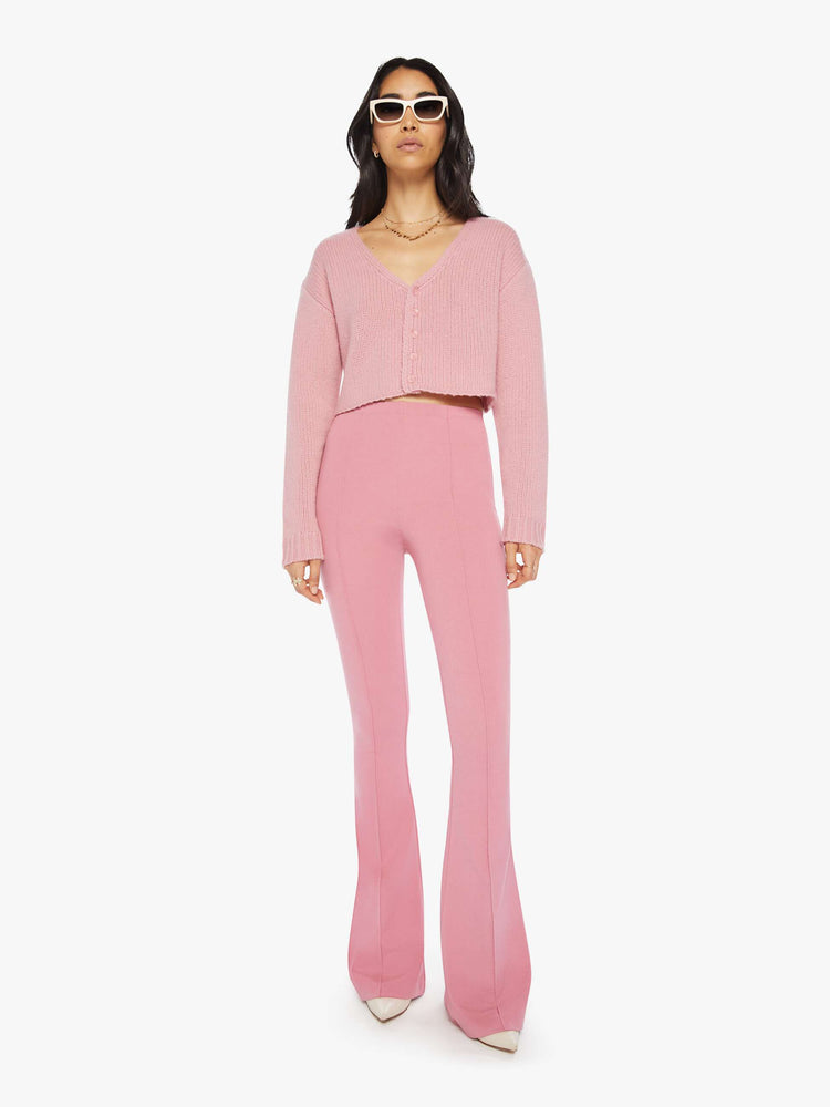 Front view of woman pink flared legging with a high rise, flared leg, long inseam and a pintuck detail down the front of each leg.