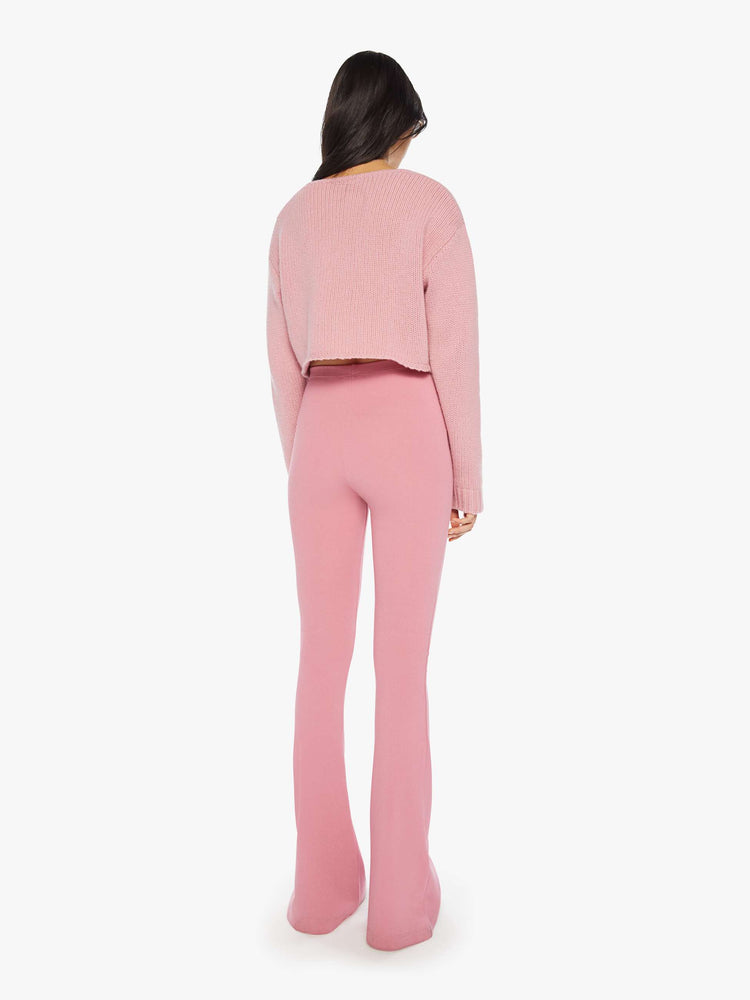 Back view of woman pink flared legging with a high rise, flared leg, long inseam and a pintuck detail down the front of each leg.