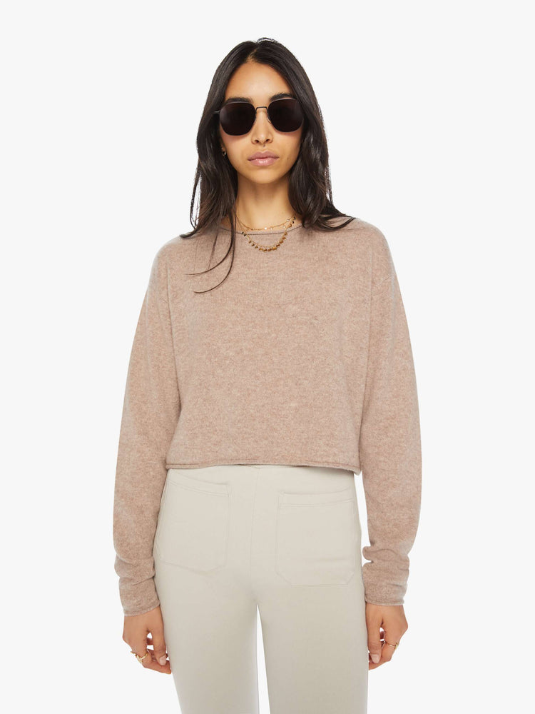 Front view of a woman toast colored sweater with a crewneck, drop shoulders, stacked long sleeves and a cropped hem.