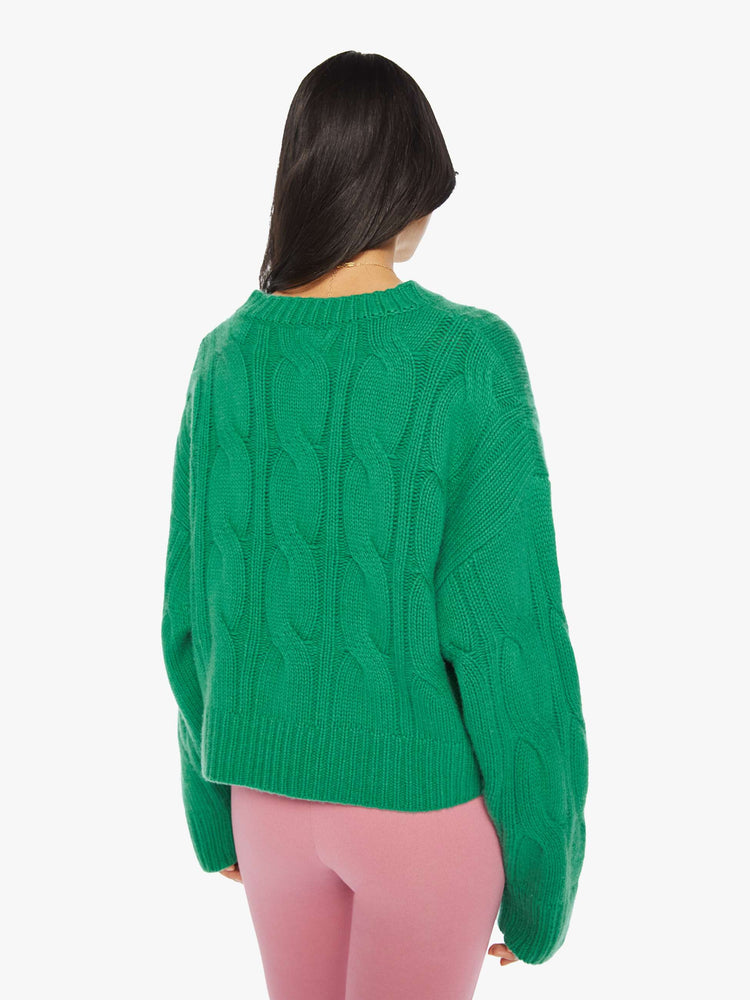 Back view of a woman green knit sweater with a crew neck, drop shoulders, extra-long sleeves and a loose fit.