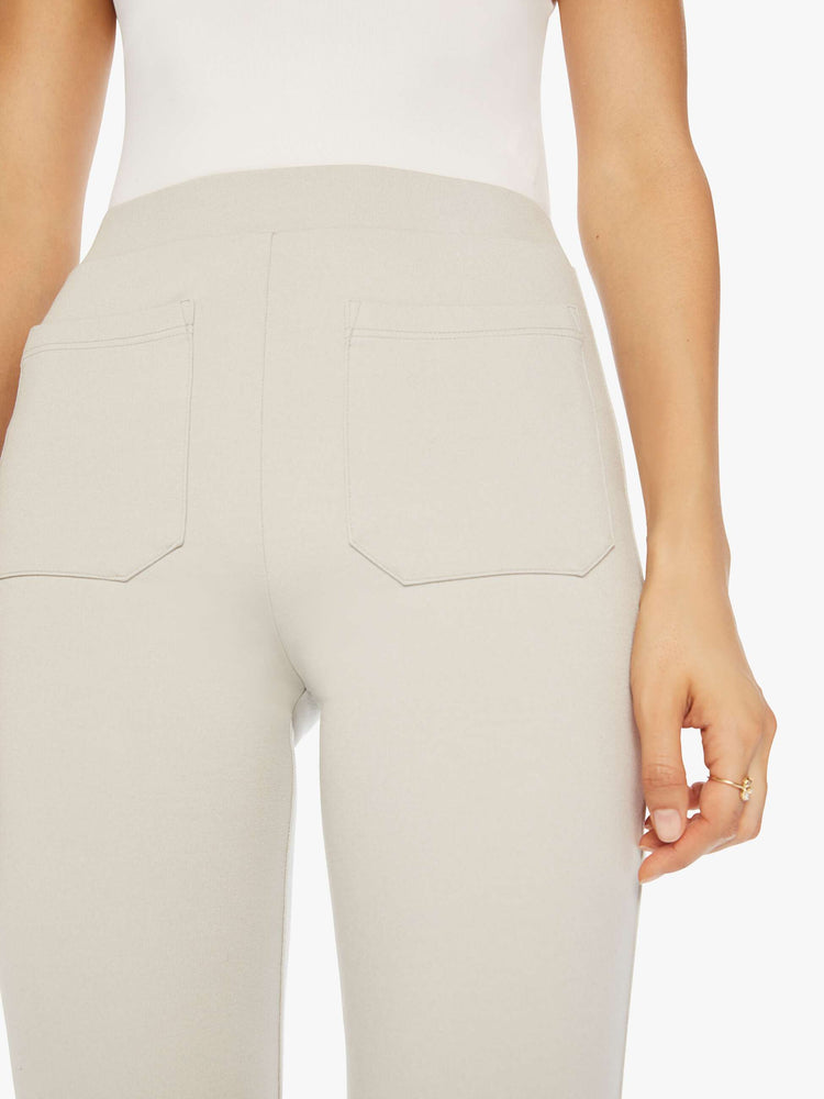 Close up view of a woman off white trousers with a high rise, straight leg, long inseam and patch pockets.