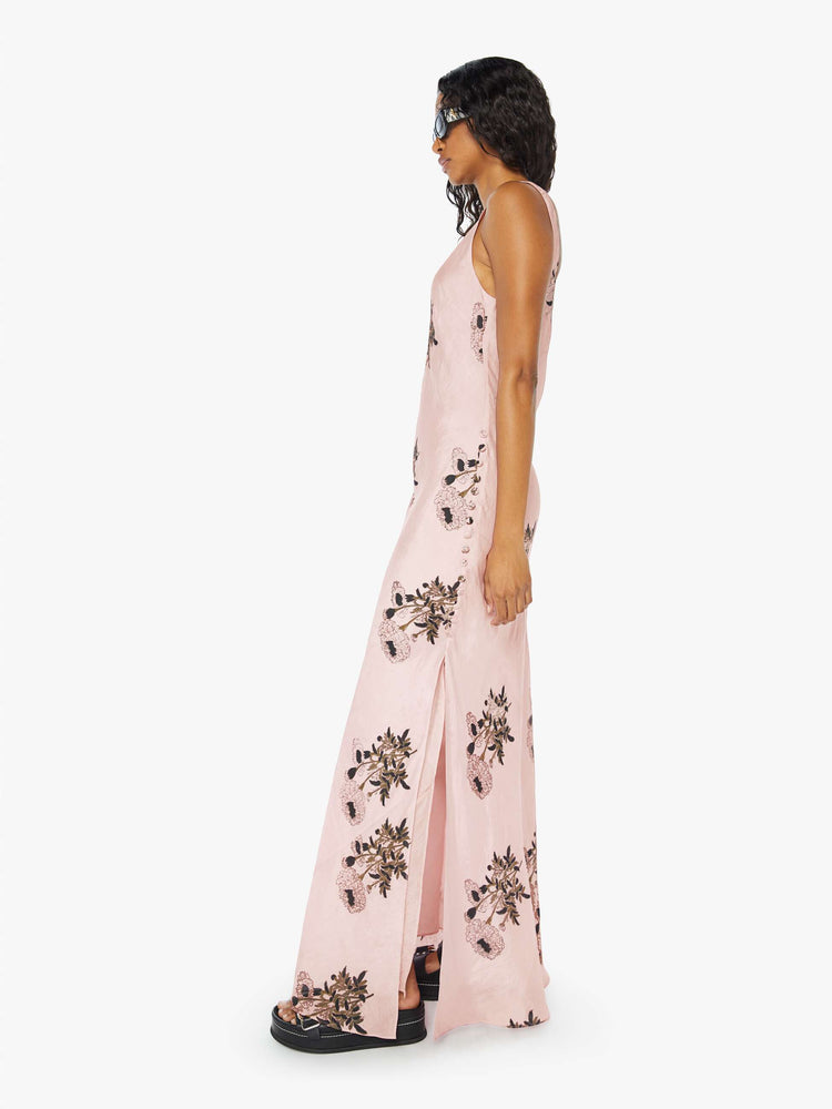 Side view of a womens pink silk dress featuring a floral print and ankle length hem..