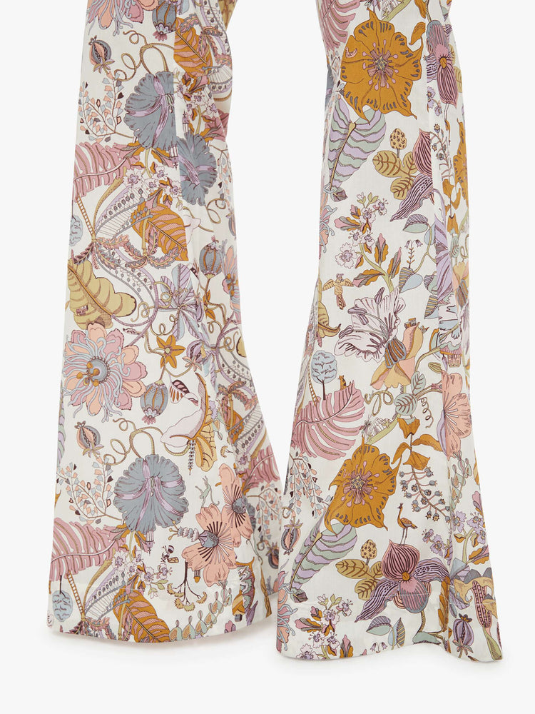 Close up hem view of a woman colorful floral print, and feature a high rise, flared leg and a long inseam.