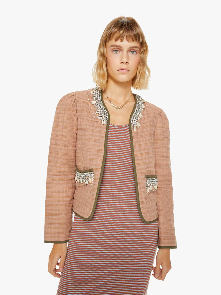Front view of a woman jacket in a pink stripe pattern with dark green trim and shell and gem applique at the collar and pockets with a V-neck, tie closure, puffed sleeves and a boxy fit.