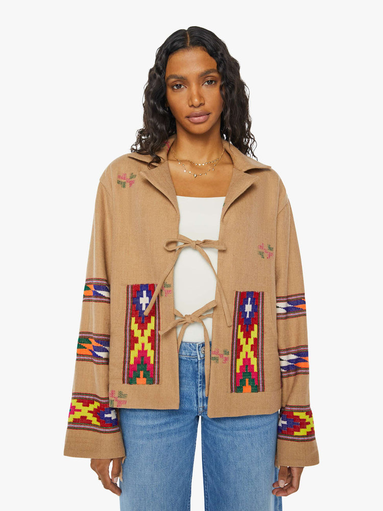 Front view of a woman Western blanket patchwork and fringe details Jacket, and features a notched collar, drop shoulders, patch pockets and a tie closure.