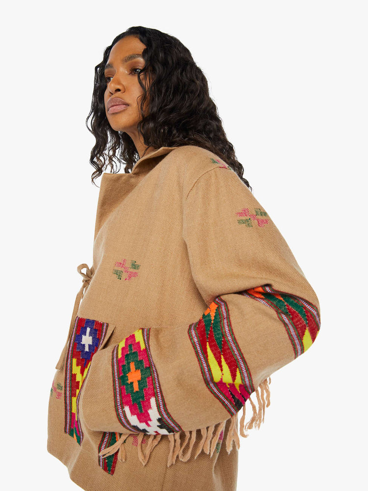 Close up view of a woman Western blanket patchwork and fringe details Jacket, and features a notched collar, drop shoulders, patch pockets and a tie closure.