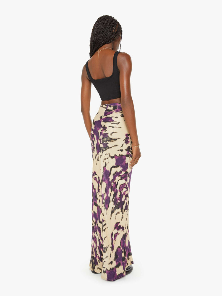 Back view of a woman violet and cream abstract print kirt features a high rise, slim fit and long hem.