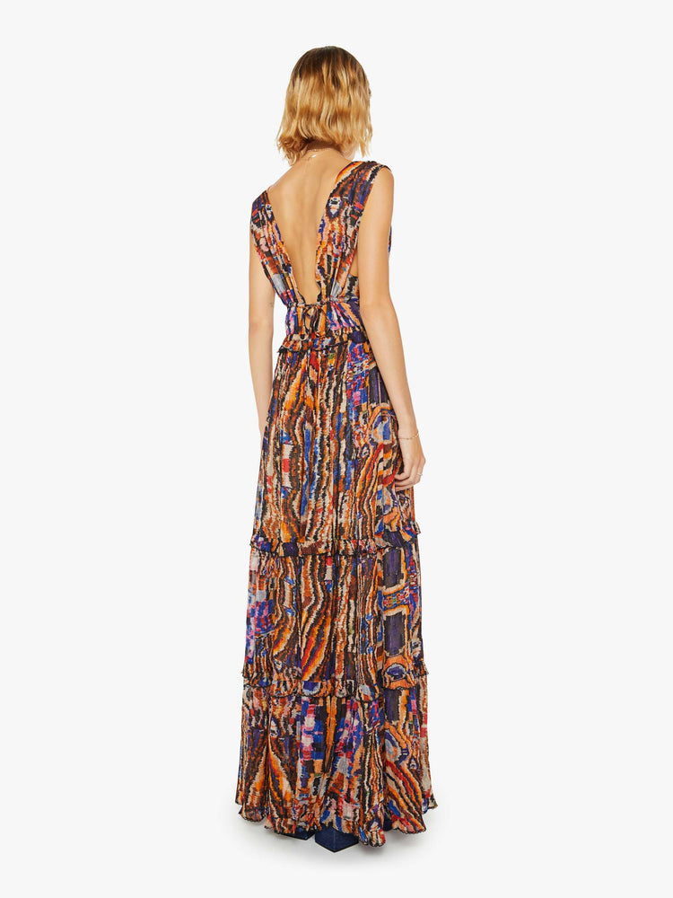 Back view of a woman colorful abstract dress features a deep V-neck, ruffled details and a tiered ankle-length skirt.