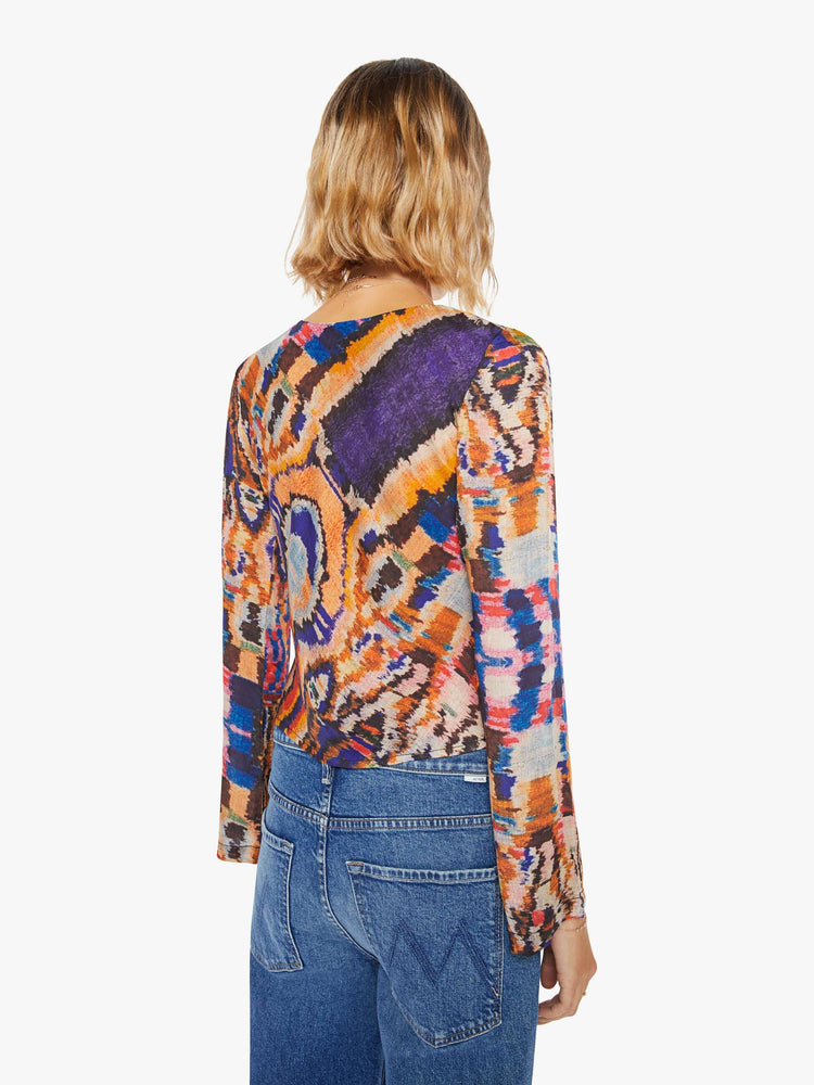 Back view of a woman colorful abstract print top with crew neck, long sleeves and a slightly cropped hem.