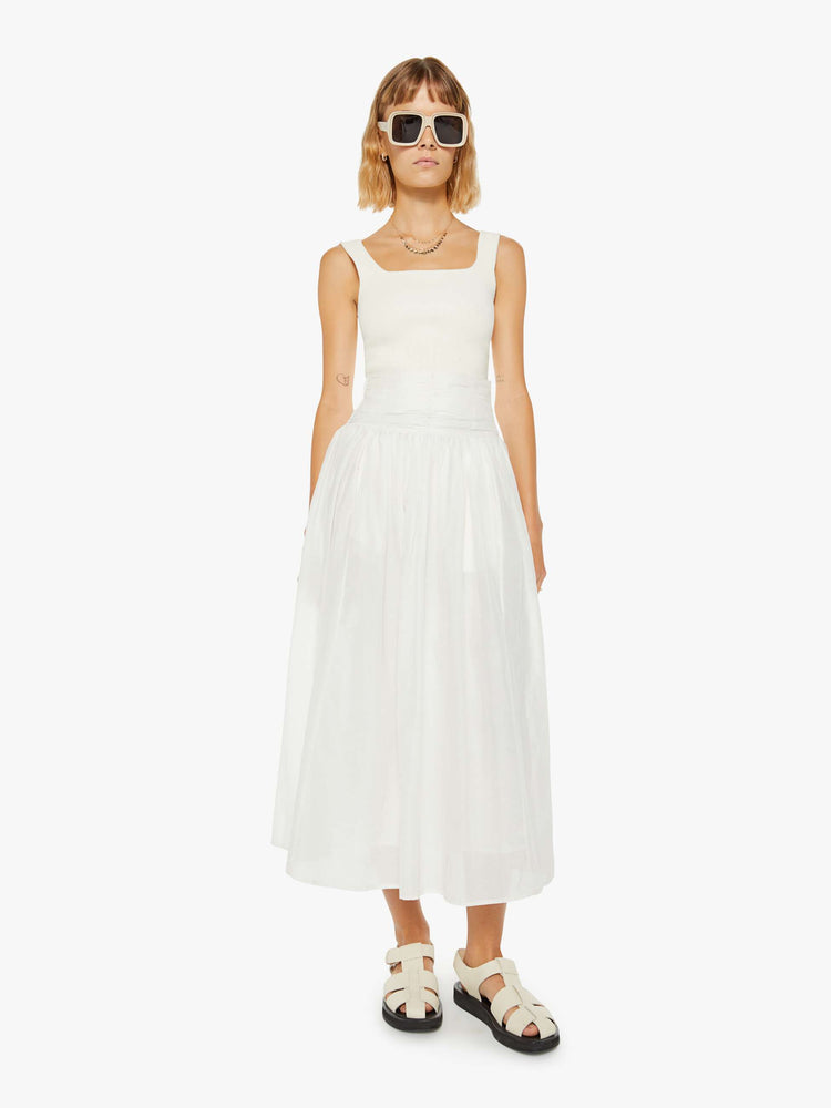 Front view of a woman off white skirt with a super high rise, tiered skirt, uneven hem and a flowy fit.