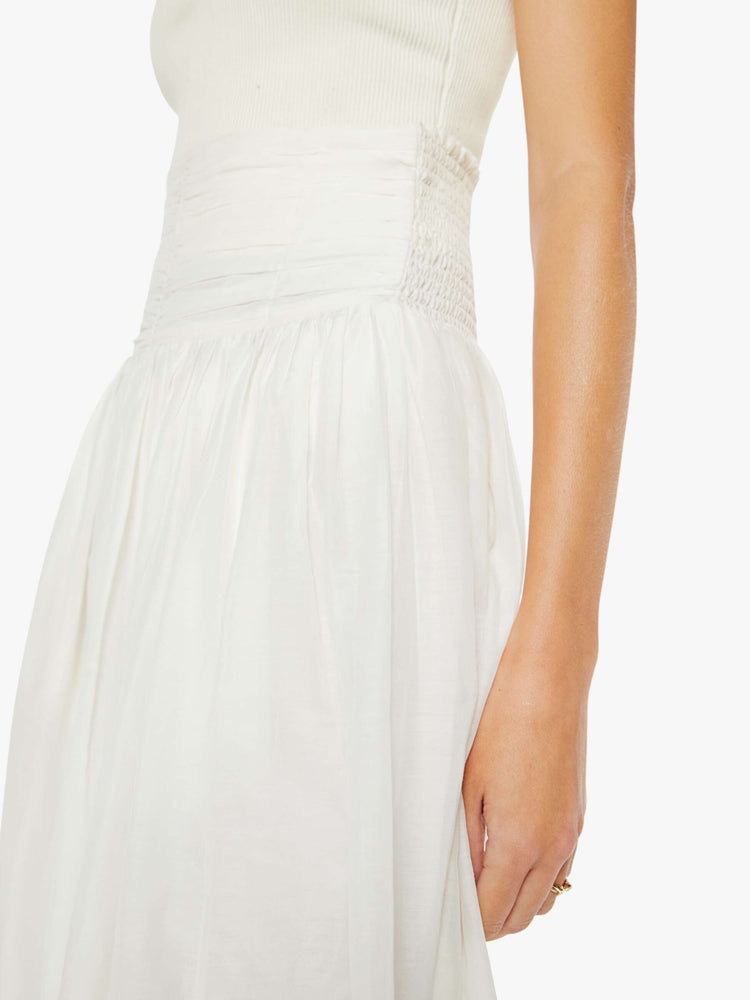 Close up view of a woman off white skirt with a super high rise, tiered skirt, uneven hem and a flowy fit.