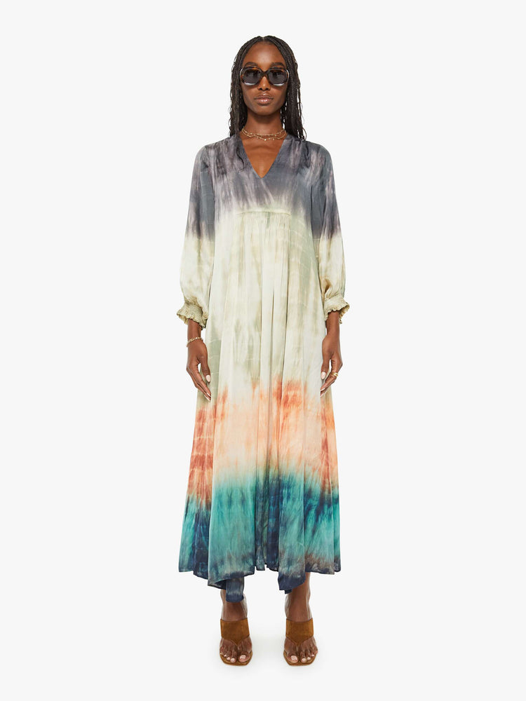 Front view of a woman maxi dress with a V-neck, cropped balloon sleeves and a loose, flowy fit in grey, green, orange, and blue ombre.