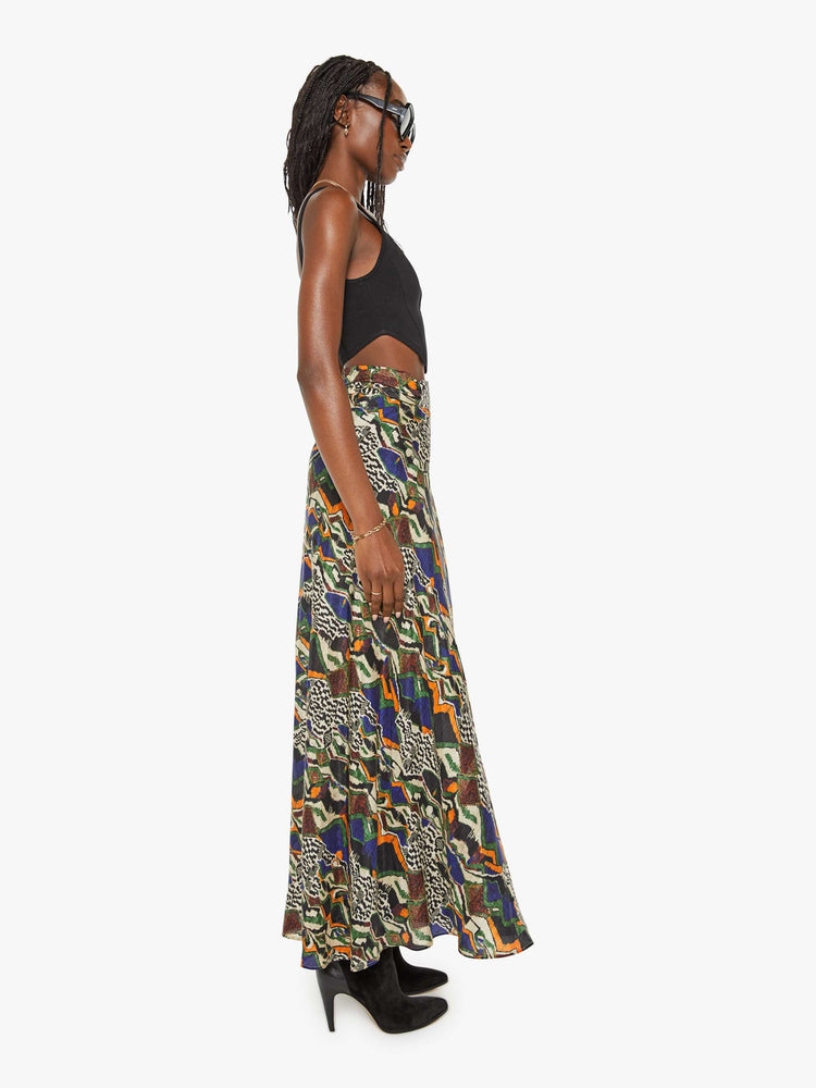 Side view of a woman bold prints and modern neutrals maxi skirt with a super high rise, thick waistband and a loose, flowy fit with an ankle-length hem.