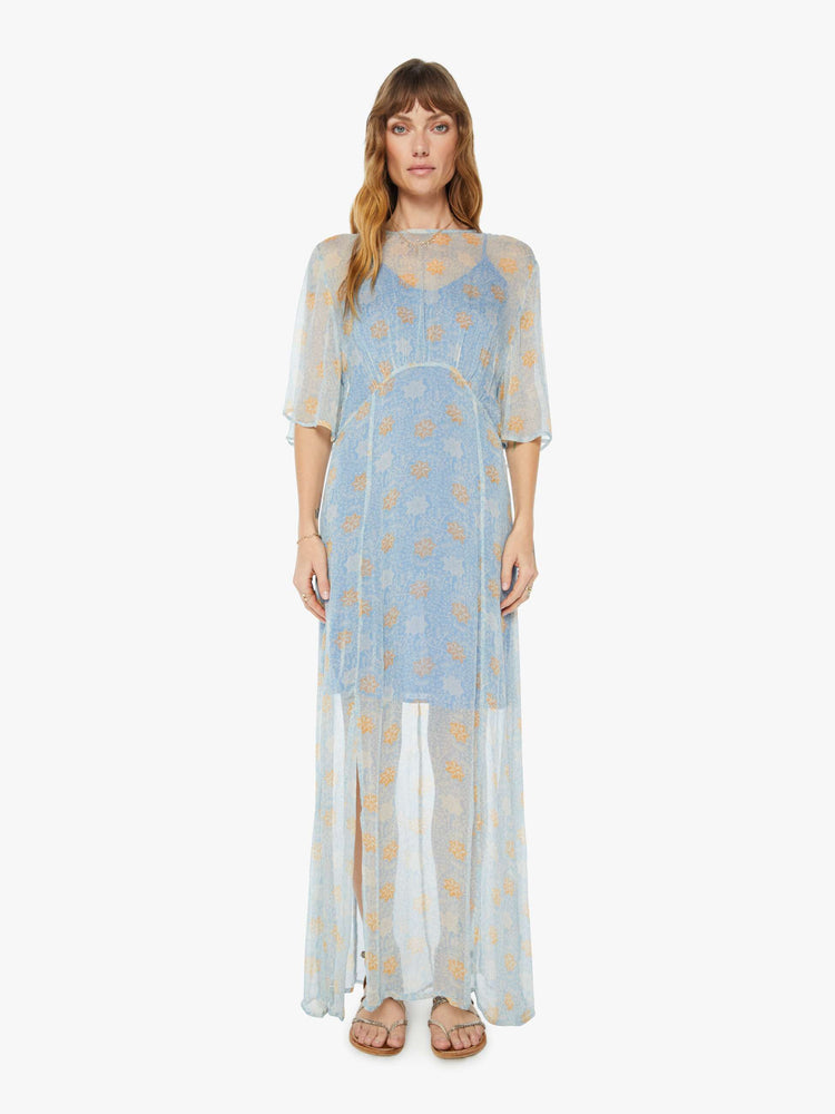 Front view of a womens sheer dress in a light blue and orange floral print featuring front slits and a blue slip.