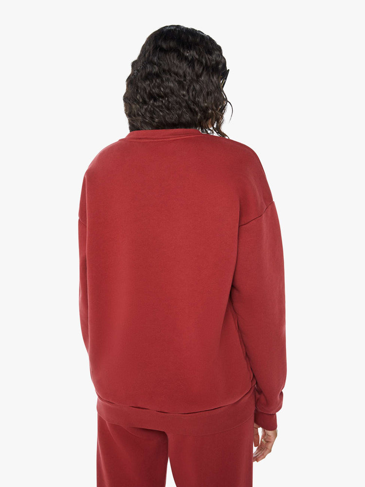 Back view of a woman crewneck sweatshirt with the brands logo on the front in crimson red hue.