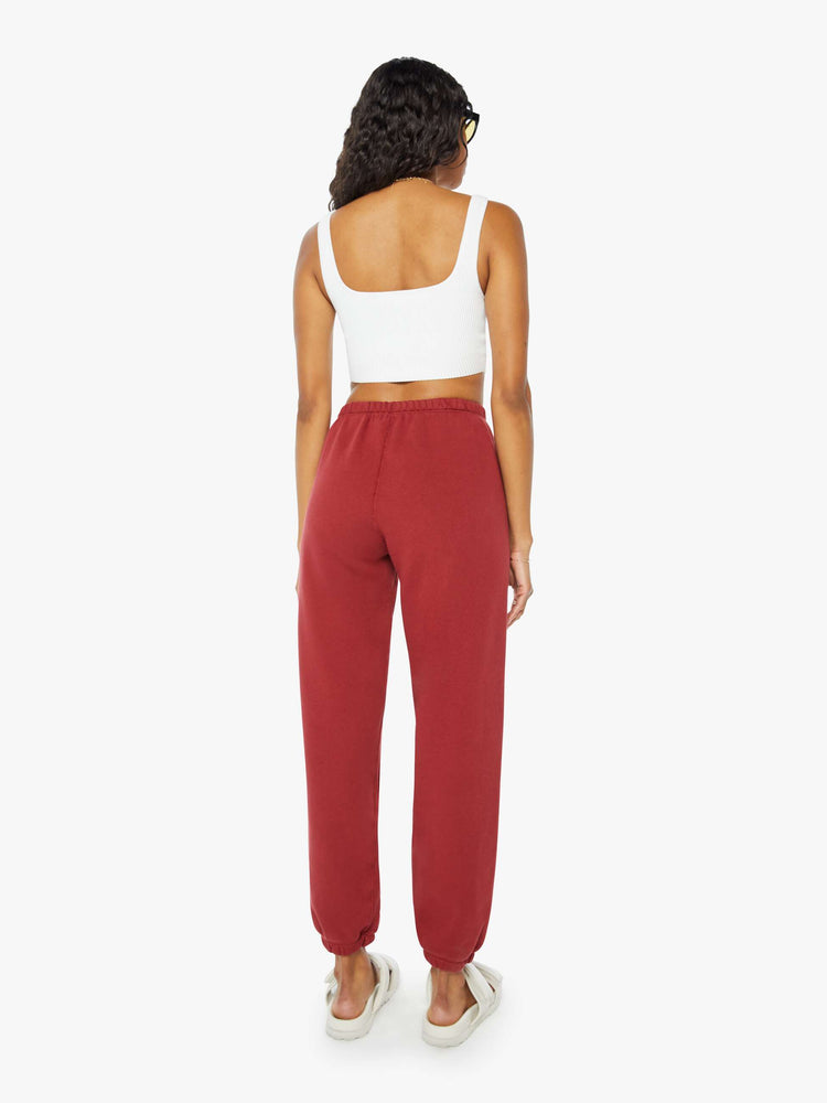 Back view of a woman crimson red sweatpants with an elastic waist and cuffs for a loose, comfortable fit.