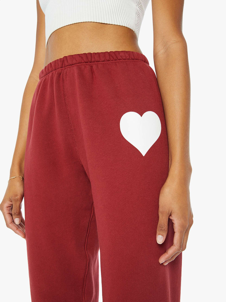 Close up view of a woman crimson red sweatpants with an elastic waist and cuffs for a loose, comfortable fit.
