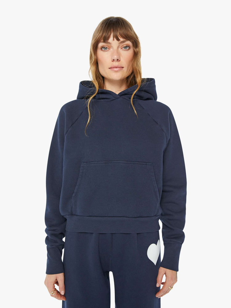 Front view of a woman navy cozy raglan hoodie with the brand's logo in white on the back.