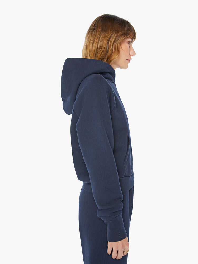 Side view of a woman navy cozy raglan hoodie with the brand's logo in white on the back.