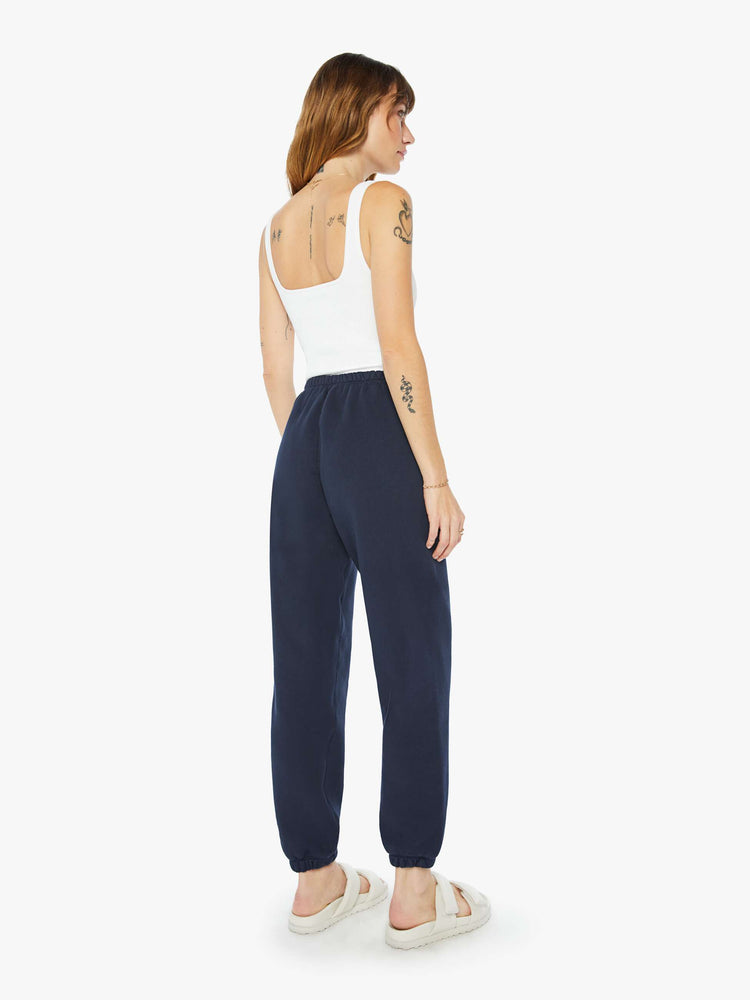 Back view of a woman navy with a white heart on the hip sweatpants with an elastic waist and cuffs for a loose, comfortable fit.