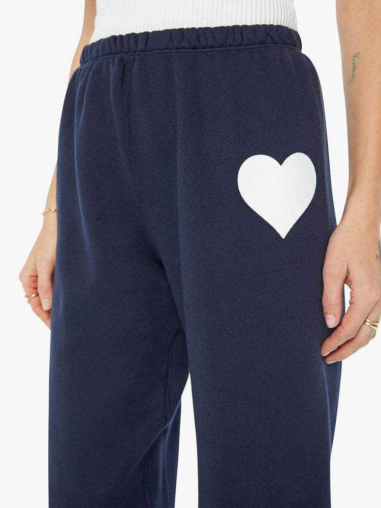 Close up view of a woman navy with a white heart on the hip sweatpants with an elastic waist and cuffs for a loose, comfortable fit.