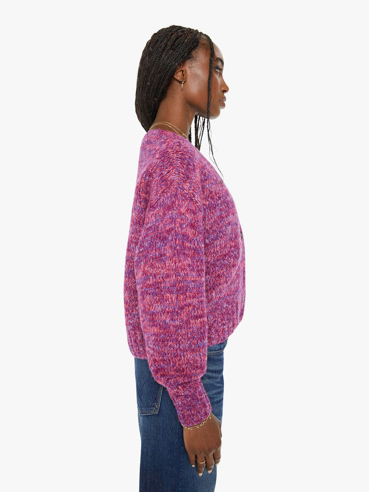 Side view of a woman magenta hue sweater with a V-neck, long sleeves, ribbed hems and buttons down the front.