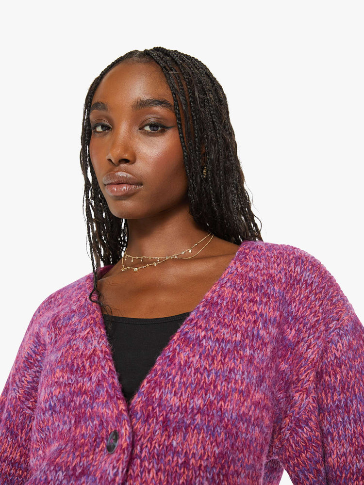 Close up view of a woman magenta hue sweater with a V-neck, long sleeves, ribbed hems and buttons down the front.