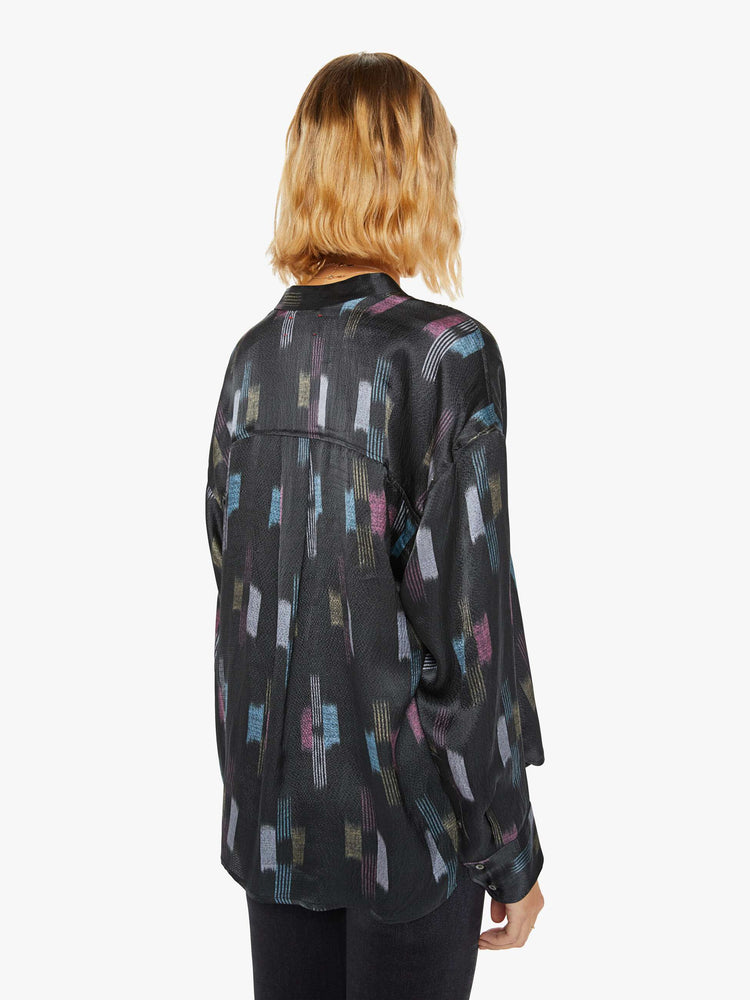 Back view of a woman black shirt with a cool toned graphic print with drop shoulders, long balloon sleeves, a slightly curved hem and buttons down the front.