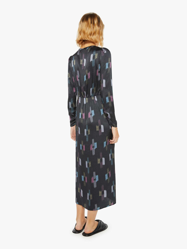 Back view of a womans black dress with cool toned graphic print with deep V-neck, gathered bodice, long sleeves and a calf-length hem.