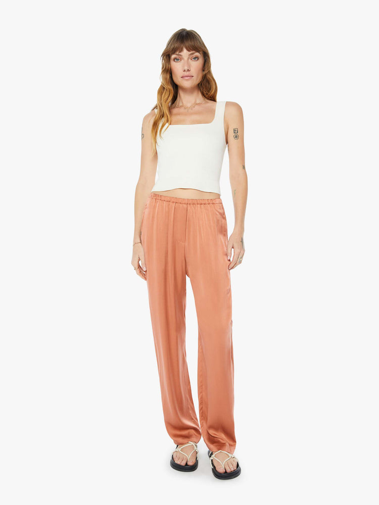 Front view of woman burnt orange high rise, elastic waist and a loose, flowy fit pant.
