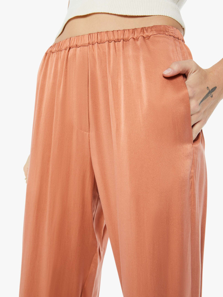 Close up  view of woman burnt orange high rise, elastic waist and a loose, flowy fit pant.